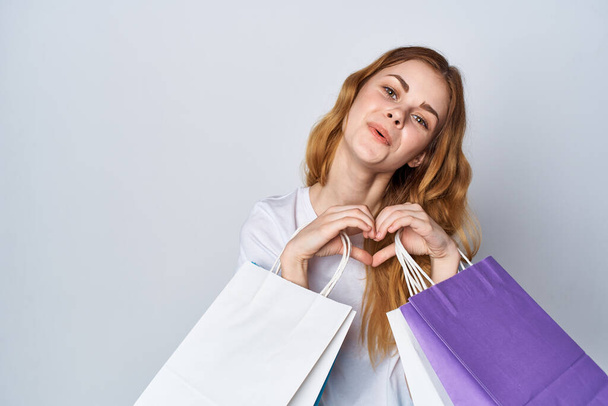 mujer alegre en una camiseta blanca compras bolsas multicolores Shopaholic - Foto, imagen
