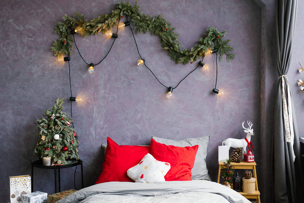 Κομψό άνετο χριστουγεννιάτικο υπνοδωμάτιο με ένα μεγάλο κρεβάτι και διακόσμηση - Φωτογραφία, εικόνα