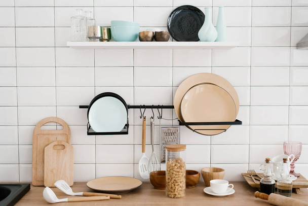 Кухонные принадлежности и посуда в светло-белой деревянной кухне - Фото, изображение