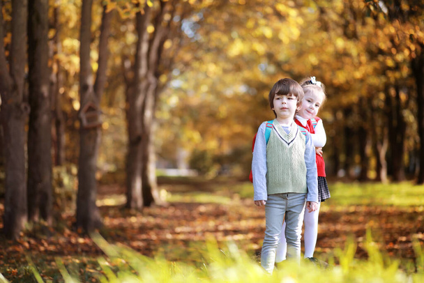 Niños con maletines para dar un paseo por el parque. Descanso escolar. El comienzo de los estudios infantiles. - Foto, Imagen