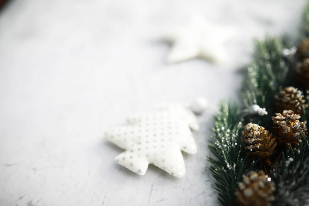 Árbol Evergreen juguetes hechos a mano, copos de nieve, globos y rama de abeto sobre fondo de piedra, tarjeta de felicitación de Navidad con espacio para texto - Foto, Imagen