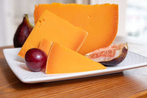 Sbírka sýrů, francouzský žlutý sýr mimolette z kravského mléka podávaný s čerstvými fíky - Fotografie, Obrázek