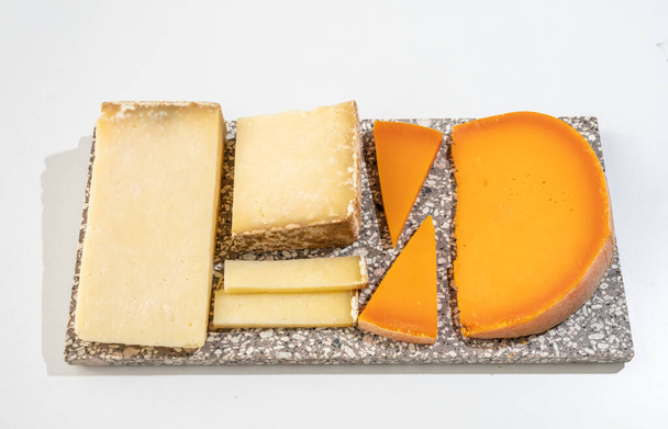 Sbírka sýrů, tvrdý francouzský sýr starý kantal fermier a žlutá mimolette ze syrového kravského mléka s kůží zblízka - Fotografie, Obrázek