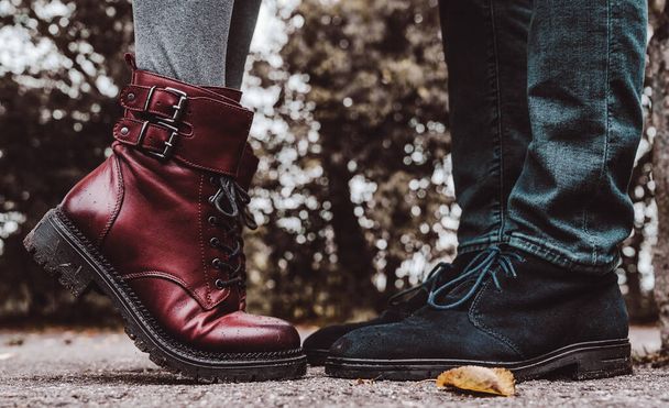 Feet of couple. Man and woman is standing opposite each other. Close-up of blue suede shoes and burgundy leather boots on tiptoe. Close-up. - Fotó, kép