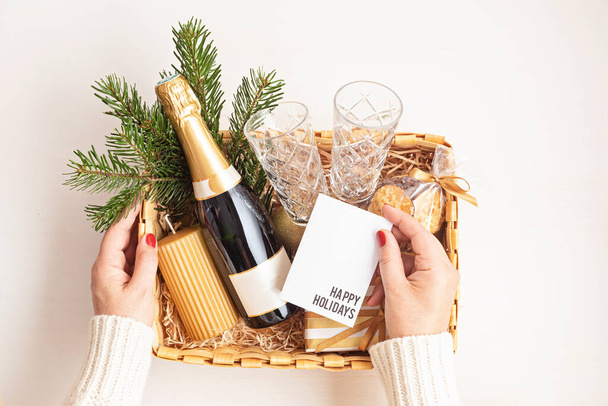 Vytříbený vánoční dárkový koš na romantickou dovolenou s lahví šampaňského, sklenicemi na víno, sušenkami a svíčkou. Firemní nebo osobní dárek pro rodinu a přátele. - Fotografie, Obrázek