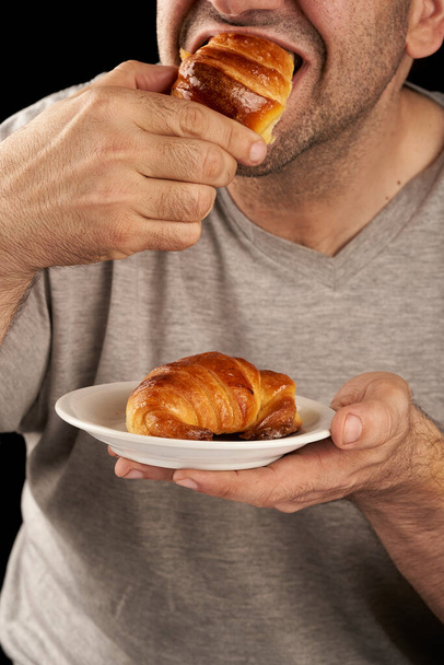 man eating sweet buttered croissants - Foto, Bild