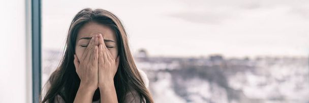 Sad upset young woman crying with mental health seasonal affective disorder at home breathing in hands panoramic background banner. Winter blues - Photo, Image