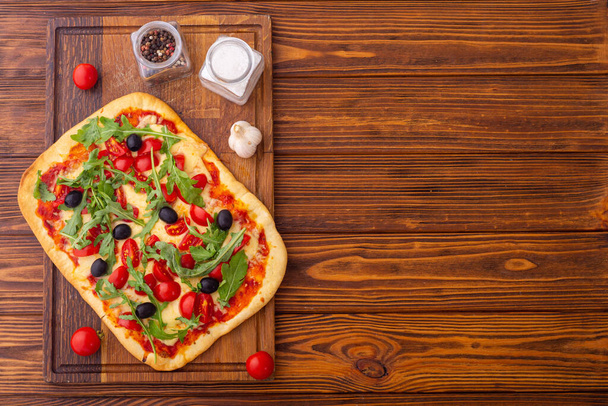 Traditional italian pizza with vegetables tomatoes cherry , olives and  arugula . Pinsa Romana - Foto, Bild