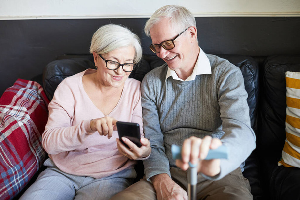 Starsza para korzystająca ze smartfona w domu spokojnej starości - Zdjęcie, obraz