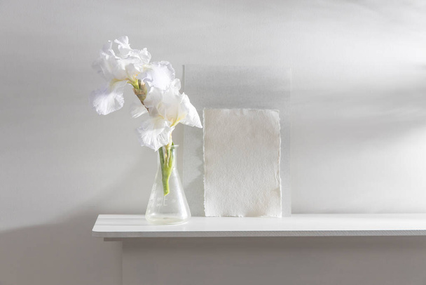 White iris flower on the background of white watercolor paper on the table. Place for your text. - Photo, Image