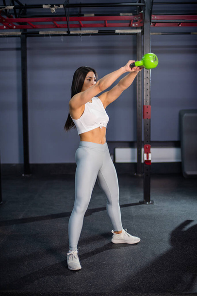 Asian woman doing exercises with dumbbells in the gym. - Foto, imagen