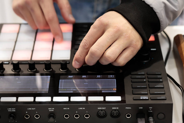 DJ микширует и воспроизводит музыку с помощью MIDI контроллера. Селективный фокус. - Фото, изображение