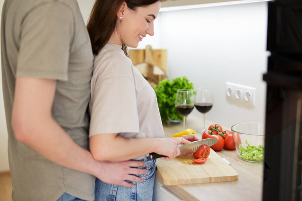 close up of young couple in love cooking dinner together at home - Foto, immagini