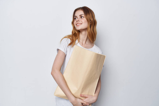 woman in a white t-shirt with a package in her hands shopping - Foto, imagen