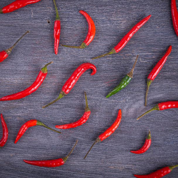 Very hot chili peppers on a wooden surface, top view - Fotoğraf, Görsel
