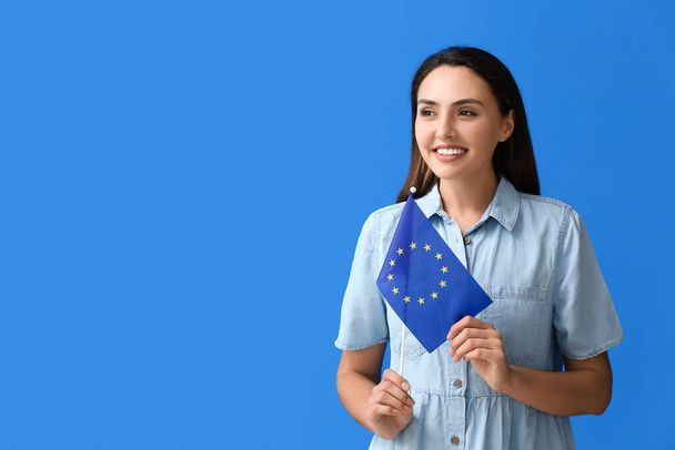 Νεαρή γυναίκα με σημαία της Ευρωπαϊκής Ένωσης στο φόντο χρώμα - Φωτογραφία, εικόνα