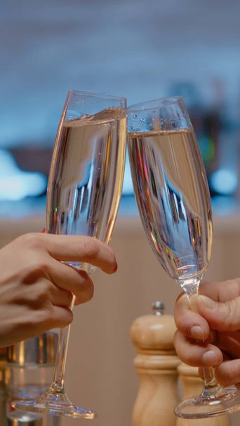 Close up of couple at festive dinner clinking glasses of champagne - Photo, Image