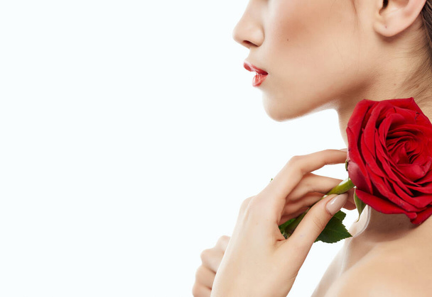γυναίκα γυμνοί ώμοι κόκκινο λουλούδι κόκκινα χείλη αίγλη - Φωτογραφία, εικόνα