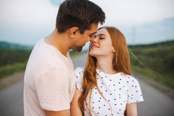 Retrato de moda de um casal se beijando à luz do sol. Temporada de primavera. Amante bonito abraçando em uma estrada. - Foto, Imagem