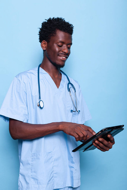 Lääketieteellinen avustaja katselee digitaalinen tabletti kädessä - Valokuva, kuva