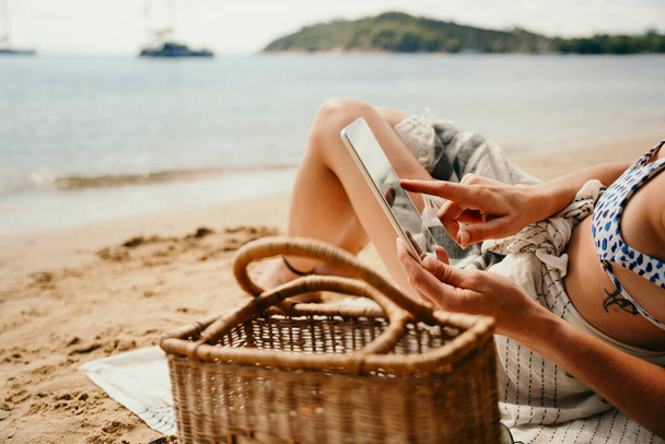 Mulher branca relaxante na praia leitura livro off tablet digital - Foto, Imagem
