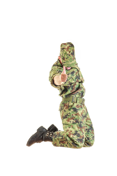 Soldat mit verstecktem Gesicht in grüner Tarnuniform und Mütze - Foto, Bild