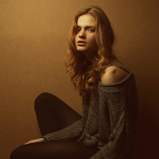 Emotive portrait of fashionable model with curly red hair and na - Foto, afbeelding