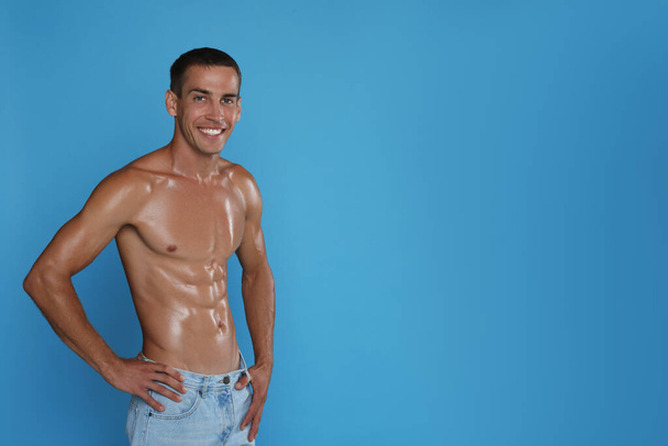 Handsome shirtless man with slim body on light blue background. Space for text - Fotografie, Obrázek