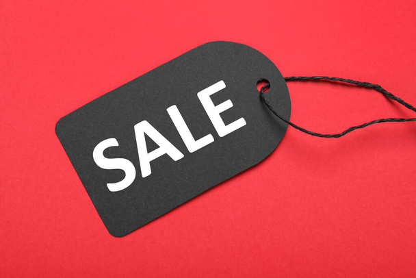 Sale tag on red background, top view. Black Friday - Фото, изображение