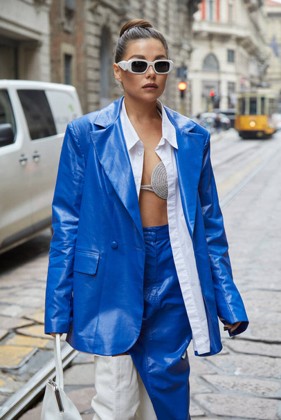MILAN, ITALY - SEPTEMBER 25, 2021: Karina Nigay with electric blue leather jacket and skirt and white leather boots before Ermanno Scervino fashion show, Milan Fashion Week street style - Valokuva, kuva