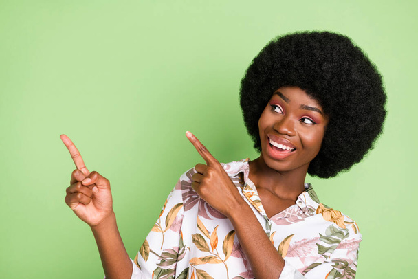 Photo of young black girl happy positive smile point fingers empty space recommend promo isolated over green color background - Fotó, kép