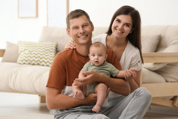 Portrait of happy family with their cute baby at home - Фото, изображение