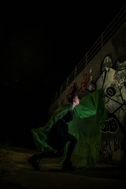 Girl posing in green draping on dark background - Φωτογραφία, εικόνα