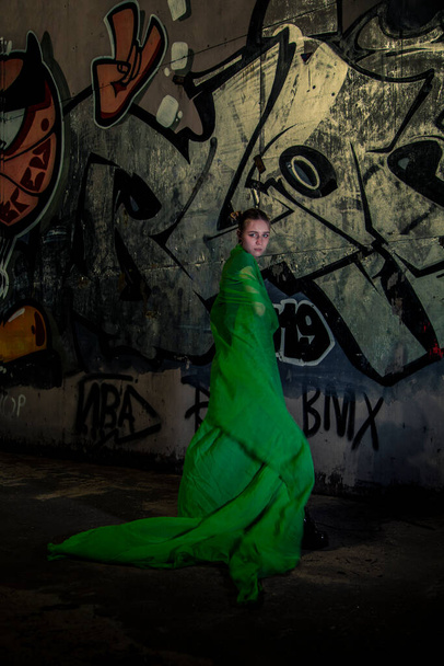 Girl posing in green draping on dark background - Foto, Imagem