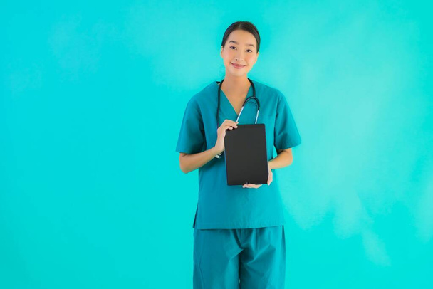 Portrait beautiful young asian doctor woman use smart tablet device on blue isolated background - Fotografie, Obrázek