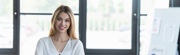 Happy businesswoman looking at camera in office, banner  - Фото, зображення