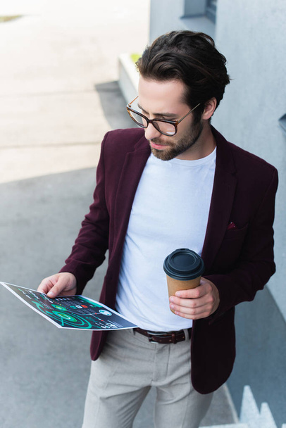 Young businessman holding coffee to go and document outdoors  - Photo, Image