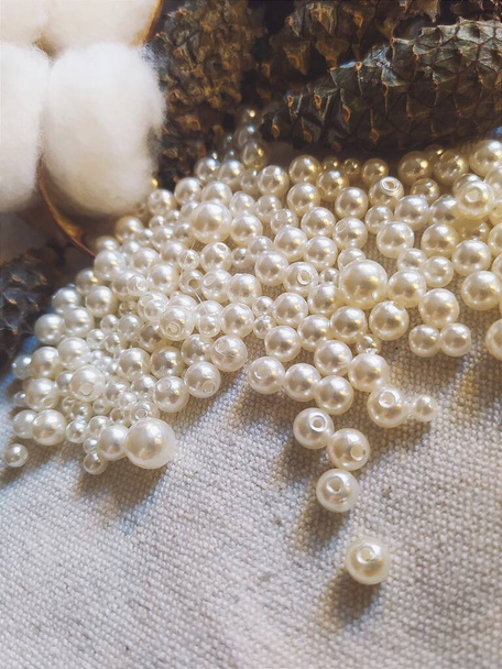 a scattering of pearl beads on a light background, beads milking decor and needlework - Photo, Image