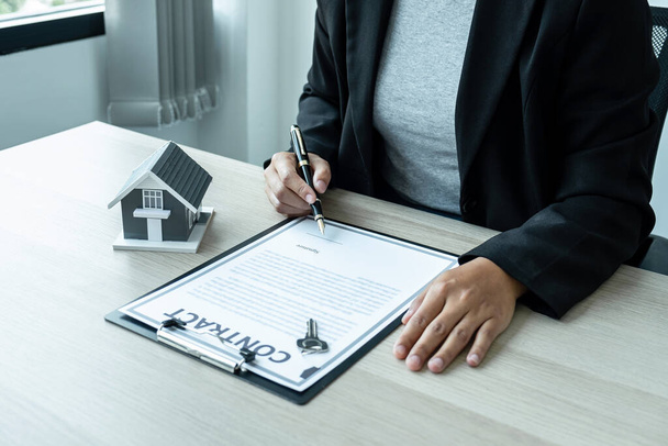 Eladó Ingatlan ügynök ad ház modell és kulcs az új ügyfél aláírása után megállapodást kötött jóváhagyott ingatlan űrlap, Lakásbiztosítás és ingatlan befektetési koncepció - Fotó, kép
