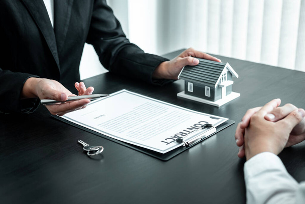 Агент по недвижимости предоставляет клиенту ипотечный кредит и обсуждает с ним форму договора о заключении решения, концепцию жилищного страхования и инвестиций в недвижимость. - Фото, изображение