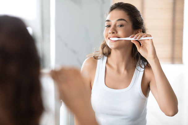 Fröhlich Frau Zähne putzen und Zahnpflege Routine im Badezimmer - Foto, Bild