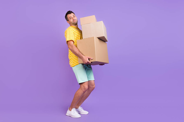 Full length body size photo man keeping heavy boxes delivery isolated pastel violet color background - Photo, image
