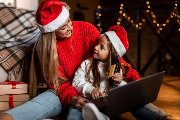 Vánoční nakupování. Máma a dcera pomocí notebooku a kreditní karty - Fotografie, Obrázek