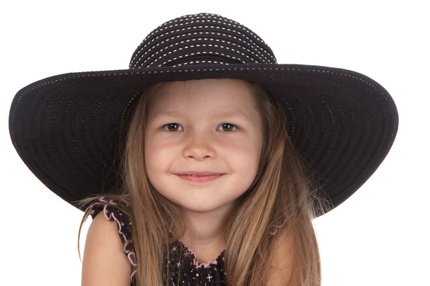 Nettes lächelndes Mädchen im Alter von fünf Jahren mit großem schwarzen Hut - Foto, Bild