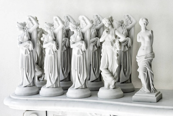 Coleção de várias estatuetas de mármore branco lembranças de mulheres em estilo antigo tradicional colocadas em pé contra a parede - Foto, Imagem