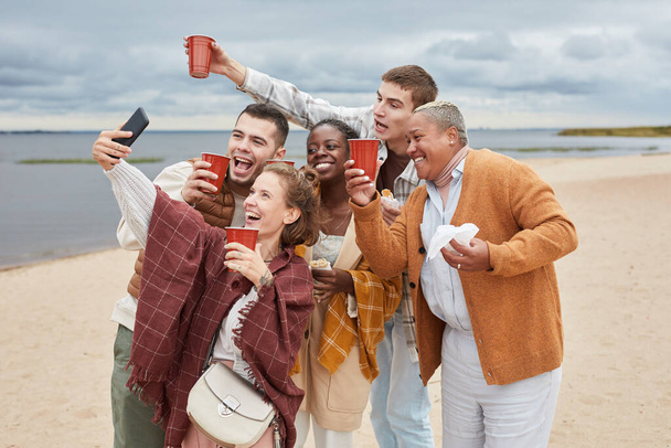 Giovani che fanno selfie in spiaggia - Foto, immagini