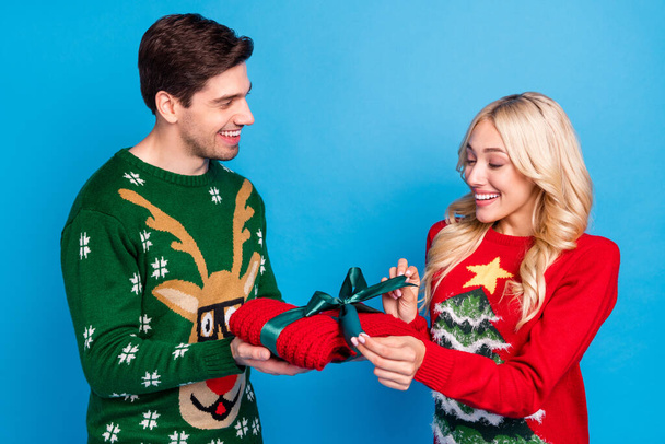Photo of pretty sweet young people wear ugly ornament pullovers opening present smiling isolated blue color background - Φωτογραφία, εικόνα