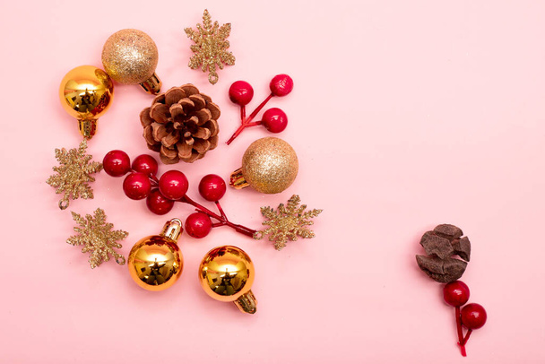 gold and red Christmas ornaments on a pink background - Foto, Imagem
