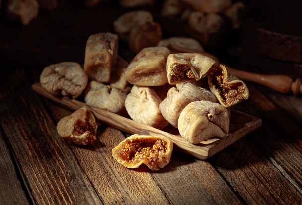 Sweet dried figs in a wooden dish on a old wooden table. - Photo, Image