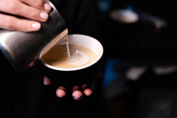ラテアートbyバリスタ。コーヒーに牛乳を注ぐ。ダークコーヒーハウス - 写真・画像